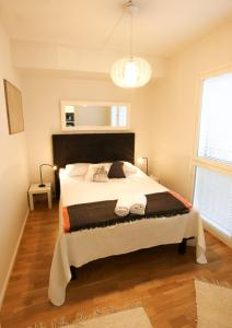 une chambre avec un grand lit dans une pièce dans l'établissement Uniikki kolmio Aurajokinäkymin, à Turku