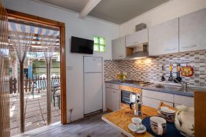 Una cocina con un refrigerador blanco y una mesa. en Appartamento Depandance 2 Villa Ada Punta Prosciutto, en Punta Prosciutto