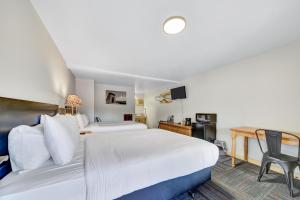 una camera d'albergo con un grande letto bianco e una scrivania di Lantern Inn a Hill City