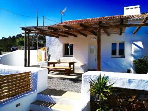una casa bianca con un tavolo da picnic di fronte di Casas de Seixe a Baiana