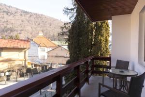 a balcony with a table and chairs and a view at Pension Tui in Sinaia