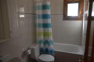 Un baño con inodoro y cortina de ducha. en Ucenda, en Bullas