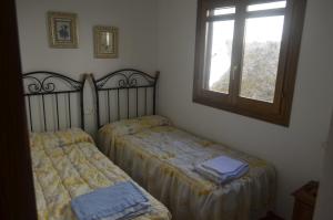 Dos camas individuales en una habitación con ventana. en Ucenda, en Bullas