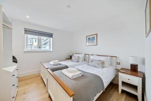 a bedroom with two beds and a desk and a window at Watchtower Reach, Sea Views, Spacious Terrace, Sleeps 6, Parking in Lynmouth