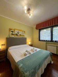 a bedroom with a bed with two towels on it at Gestiona2R- Casa grande para 12 en Llanes 6 dormitorios Jardín y espacio exterior in Llanes