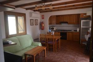 Una sala de estar con un sofá verde y una mesa. en La Molineta, en Bullas
