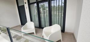 two white chairs sitting next to a glass table at Vacansis Masamagrell Bajo Loft Tomas y Valiente in Masamagrell