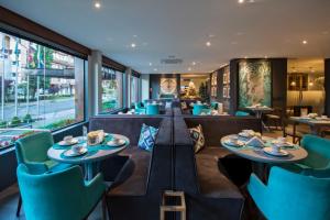 a restaurant with two tables and blue chairs at Hotel Cercano in Gramado