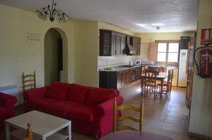 Una sala de estar con un sofá rojo y una cocina. en Pinar Hermoso, en Bullas