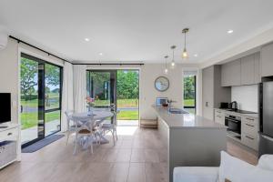 a kitchen and living room with a table and chairs at Peter's Puketaha Homestay in Ruakura Junction +29 photos