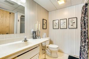 a bathroom with a toilet and a sink and a mirror at Lakefront Home with Private Beach in Rhinelander! in Rhinelander +32 photos