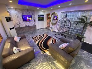 Una sala de estar con dos sofás y un espejo. en 3 Bed room Luxurious Duplex, en Lagos