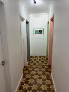 a hallway with white walls and a checkered floor at Cuxipa House in Sao Paulo