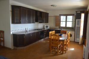 una cocina con armarios de madera, mesa y sillas en Pozico, en Bullas