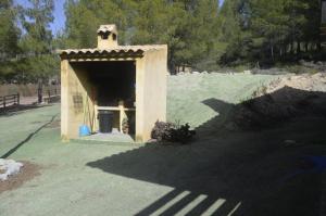 un pequeño edificio en un campo con un cubo de basura en Pozico, en Bullas