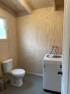 a small bathroom with a toilet and a sink at El Tilo Cabin - Hot Tub & Lake Ranco Views in Lago Ranco
