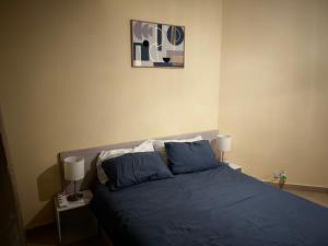 1 dormitorio con 1 cama azul y 2 lámparas en Cosy and modern flat in Mauritius, en Flic en Flac