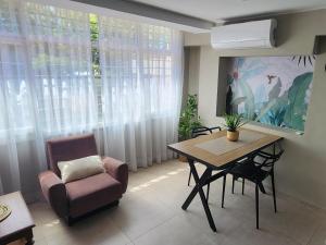 ein Wohnzimmer mit einem Tisch und einem Stuhl in der Unterkunft Emilio Jofré II - Departamento céntrico y luminoso in Villa Marini