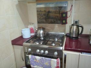 a kitchen with a stove with two tea pots on it at Квартира в тихом дворе in Baku