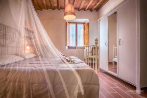 a bedroom with a bed with a mosquito net at Tognazzi Casa Vacanze - Casa Il Giglio in Certaldo