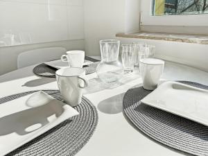 a dining table with plates and glasses and a laptop on it at Heart of Hannover Apartment in Hannover