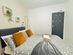 a bedroom with a bed with orange and gray pillows at Room 2 Shared House in L7 in Liverpool