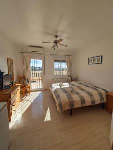 Un dormitorio con una cama y un ventilador de techo. en Casa Castillo, en Huércal-Overa