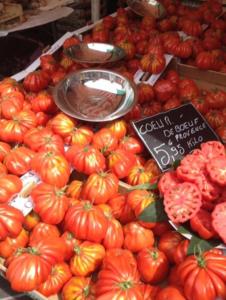 a pile of tomatoes on a display in a market at Le Fontana in Nice