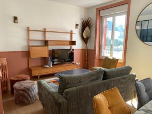 a living room with a couch and a tv at La villa Alixel in Pléneuf-Val-André
