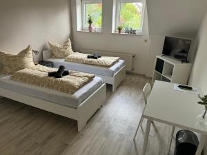 a living room with two beds and a television at Pension Platzhirsch Eichsfeld in Geisleden