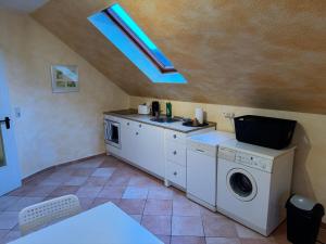 a kitchen with a washing machine and a sink at Pension Platzhirsch Eichsfeld in Geisleden