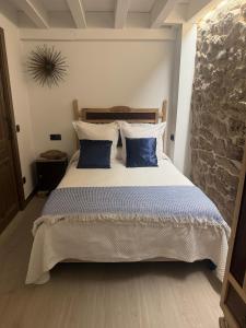 ein Schlafzimmer mit einem großen Bett und blauen Kissen in der Unterkunft Casa Rural Garabitero in Laguardia