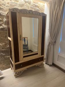 einen Spiegel auf einem Stand mit einem Stuhl in einem Zimmer in der Unterkunft Casa Rural Garabitero in Laguardia + 31 Fotos