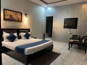 a bedroom with a bed and a television in it at Hotel Tulsi in Haldwāni