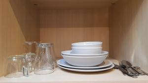 a pile of bowls and plates sitting on a shelf at Suite de charme avec terrasse, spa extérieur et petit piscine in Lédenon