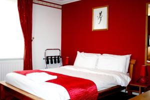 1 dormitorio rojo con 1 cama con pared roja en Ilfracombe House Hotel - near Cliffs Pavilion, en Southend-on-Sea