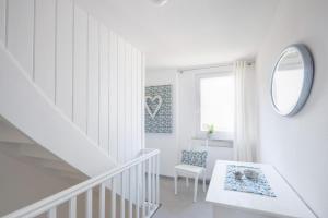 a white room with a staircase and a mirror at Ferienwohnung Am Stadtpark in Schwäbisch Hall