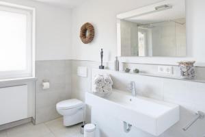 a white bathroom with a sink and a toilet at Ferienwohnung Am Stadtpark in Schwäbisch Hall