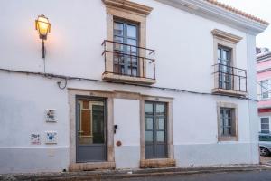 a white building with windows and a street light at Oakmoon House in Faro