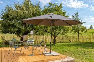 a table and chairs under an umbrella on a deck at Haus Grün in Niederstetten