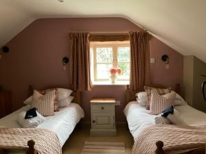 two twin beds in a room with a window at Beck cottage in Rosedale Abbey