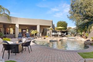 a patio with a pool and chairs and a house at Dale in Scottsdale