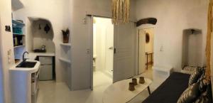 a white kitchen with a sink and a table in a room at Milos Heritage Home 1883 in Adamantas