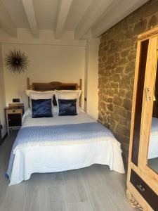 ein Schlafzimmer mit einem Bett mit einer Steinwand in der Unterkunft Casa Rural Garabitero in Laguardia