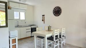 a kitchen with a table and chairs and a clock on the wall at Rincón del Río in San Antonio de Areco