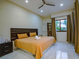 a bedroom with a bed with yellow sheets and a window at Hotel y Suites Los Encantos in Sayulita +97 photos