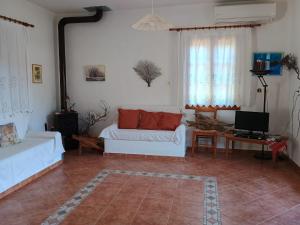 a living room with a white couch and a tv at Villa Foti in Astris