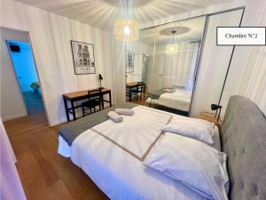 a bedroom with a bed with two towels on it at L'Éclat Champenois - Terrasse-Gare-Arena in Reims +33 photos