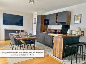 a kitchen with a wooden table and a dining room at L'Éclat Champenois - Terrasse-Gare-Arena in Reims