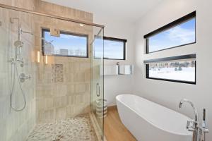 ein Badezimmer mit Badewanne und Glasdusche in der Unterkunft Modern Ski-InandOut Home in Brian Head with Deck in Brian Head + 31 Fotos